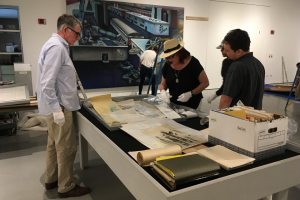 Jim Sweeters (left) works with muralist Judy Baca (center) to put together an exhibition of her work at the CSUN Art Galleries in 2017.