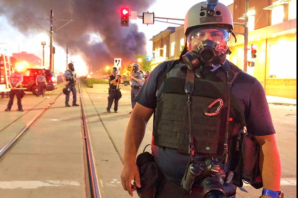 CSUN alumnus and Associated Press photojournalist Julio Cortez poses in front of a police line in St. Paul, Minn., during coverage of the George Floyd protests on May 28, 2020. Hours later, he took a photograph that eventually won a Pulitzer Prize. (Photo by John Minchillo)