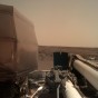 A photo of the InSight lander on Mars' horizon taken from a camera attached to the lander's robotic arm.