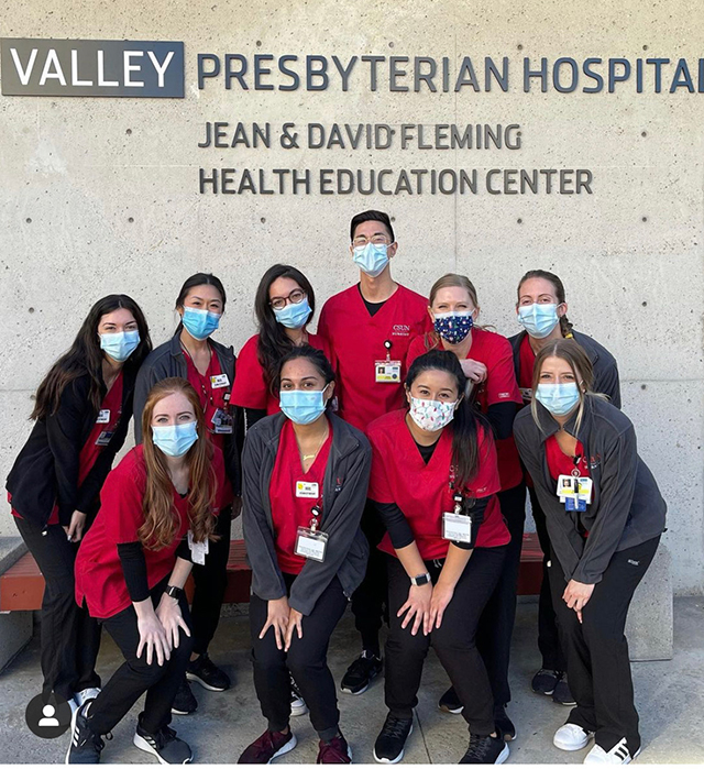 A group of masked CSUN nursing students pose in front of Valley Presbyterian Hospital.