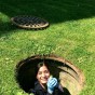 Officer Jennifer Sanchez in a manhole by Kurland Hall grabbing the last duckling.