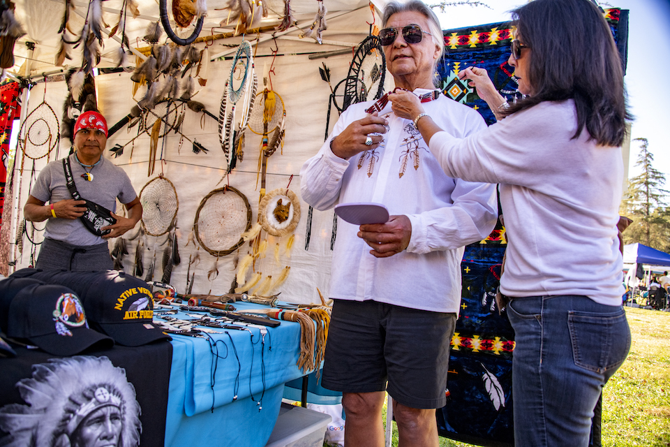 Man tries on bolo tie at CSUN Powwow craft fair.