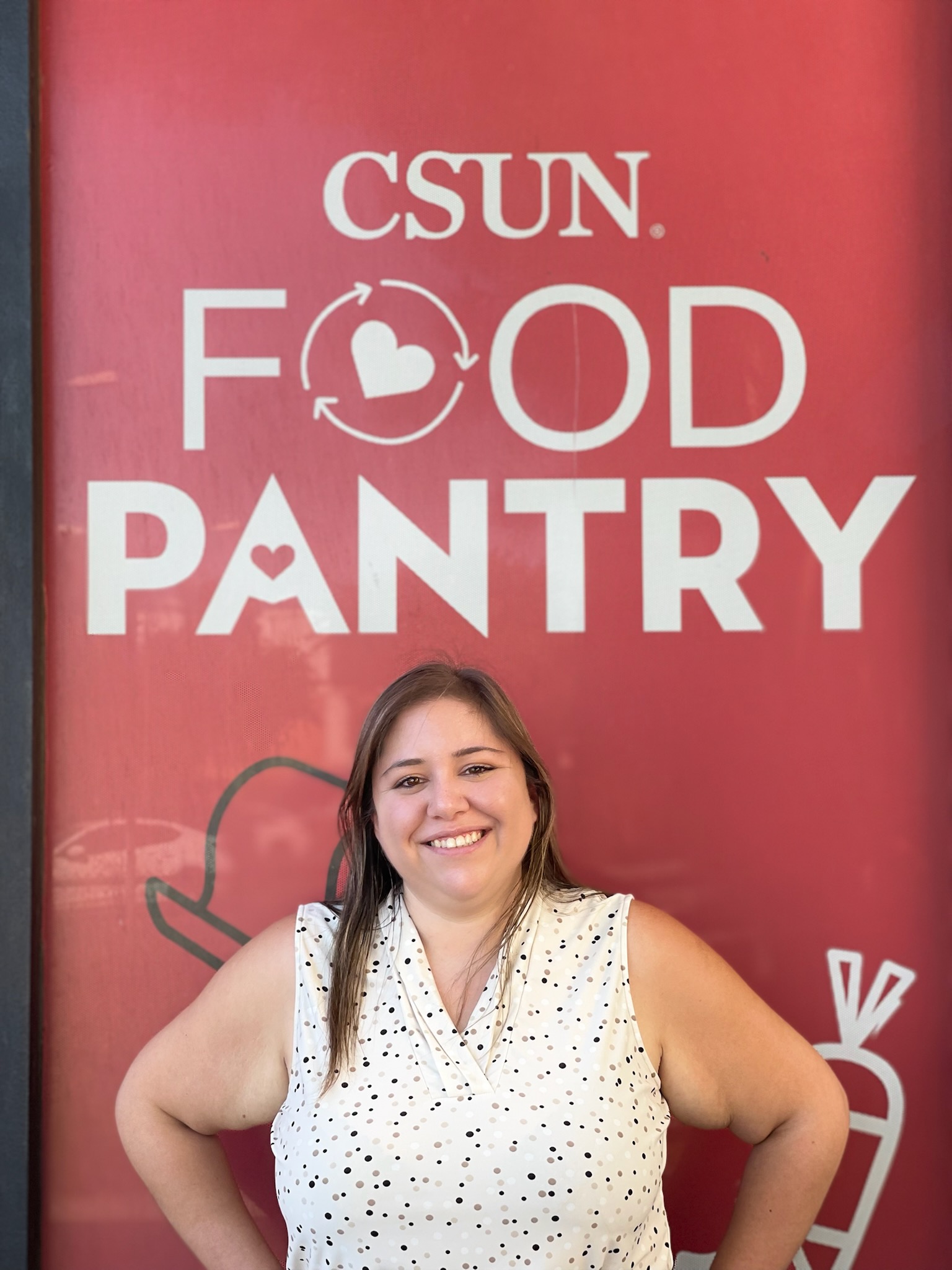 Christel Bowen smiling under the CSUN Food Pantry sign