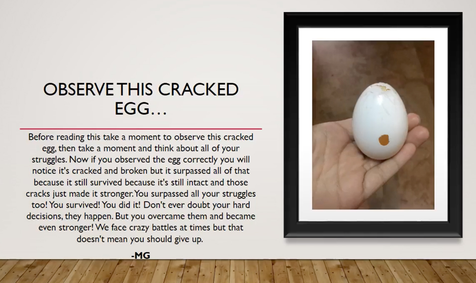 A student photo of a cracked egg, the shell barely holding together, as it is placed delicately in a hand.