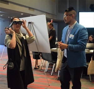 CSUN psychology assistant professor Thomas Chan demonstrates to a woman his augmented reality research. 