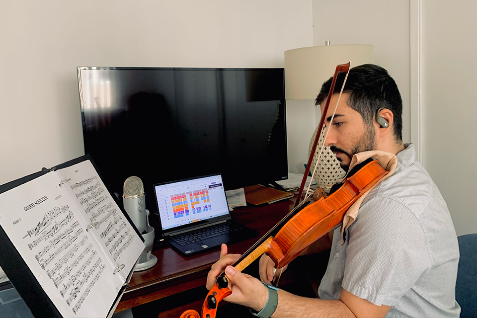 Violinist Sahand Zare records his part in the digital orchestra from a home studio.